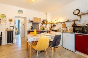 Une cuisine compacte comprenant une table à manger, des chaises, un réfrigérateur et un four à micro-ondes.