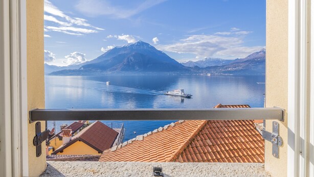 A balcony with a view of a mountain, calm lake, and boats. - Breathtaking Lake View (Varenna)