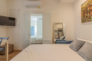 A bedroom with a bed, a desk, a chair, a TV, and a kitchenette. - Dream Lake Home in Varenna (Varenna)