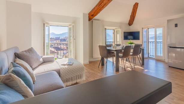 Eine moderne Wohnung mit Essbereich, Küche und einem großen Fenster mit Bergblick.