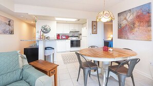 Un espacio habitable compacto con comedor, kitchenette y sofá.