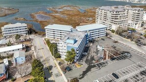 Zona costera con edificios modernos, un estacionamiento y vista al mar.