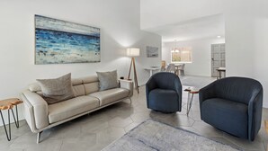 A modern living room with a sofa, two armchairs, a coffee table, and a painting on the wall. - Discover the Sedona Oak Creek Quiet Retreat, a cozy 2-bedroom condo in Village of Oak Creek. (Sedona)