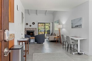 Ein modernes Wohnzimmer mit Kamin, einem Essbereich mit weißem Tisch und Stühlen sowie einem Sofa.