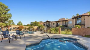 A pool area with lounge chairs and a hot tub, surrounded by buildings with balconies. - Discover the Sedona Oak Creek Quiet Retreat, a cozy 2-bedroom condo in Village of Oak Creek. (Sedona)