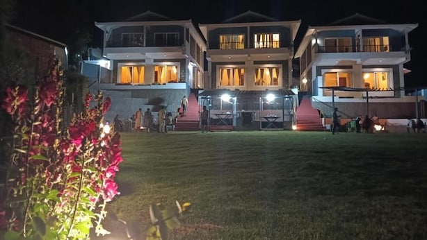 A two-story building with multiple windows and a well-lit entrance. - Longwood Resorts (Kotagiri)
