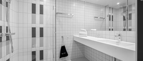 A modern bathroom with a glass-enclosed shower, a white sink, and a mirror.