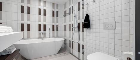 Un baño moderno con una bañera independiente, un inodoro y una zona de ducha.