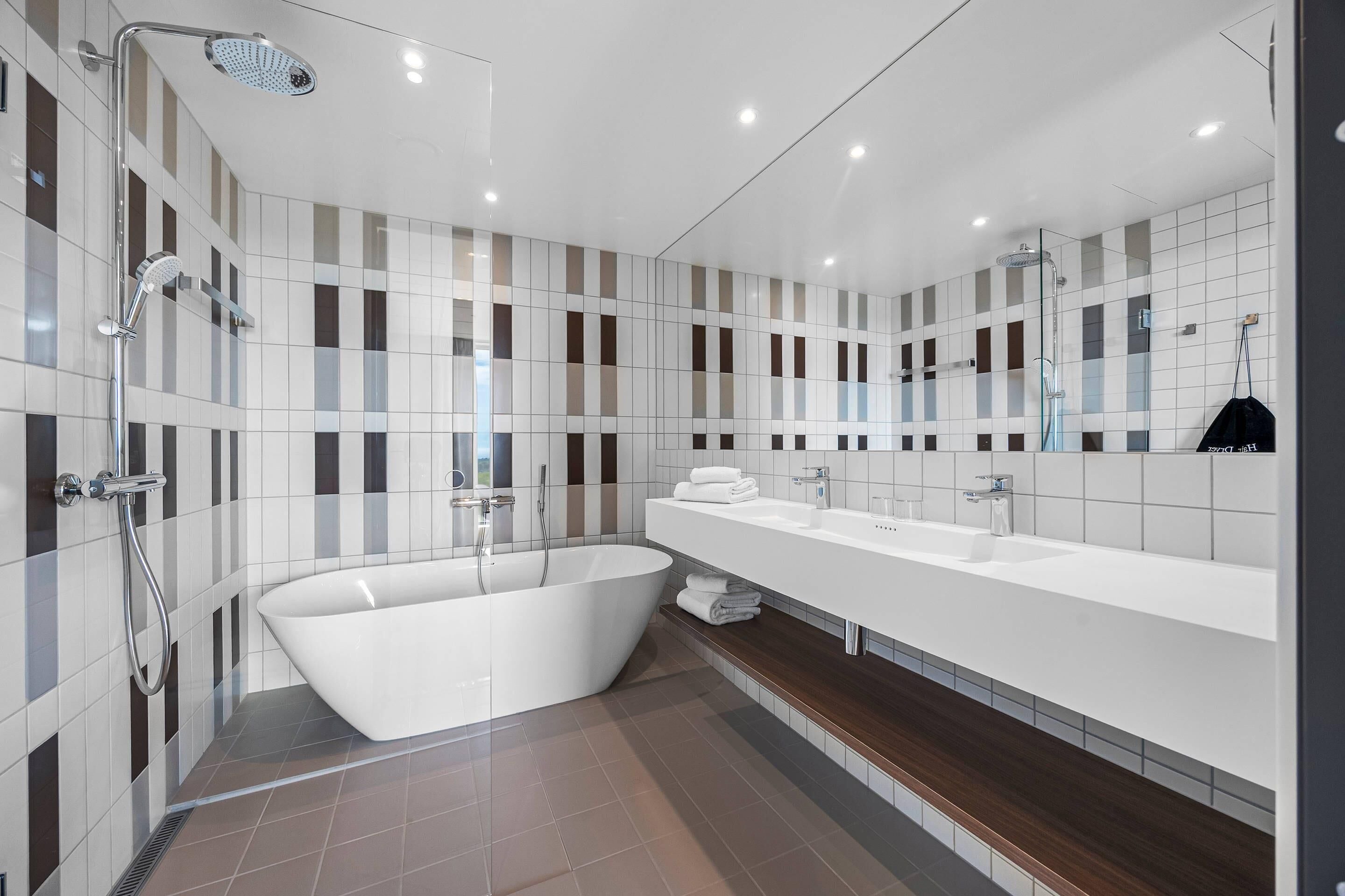 Une salle de bain moderne avec une baignoire sur pieds, un grand miroir et un meuble-lavabo avec un évier.