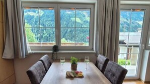 A dining table with two chairs, a plant, and a fruit platter. - Apartment 5. (Flattach)