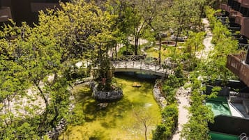 Un jardin aménagé avec un pont, un étang et un sentier.