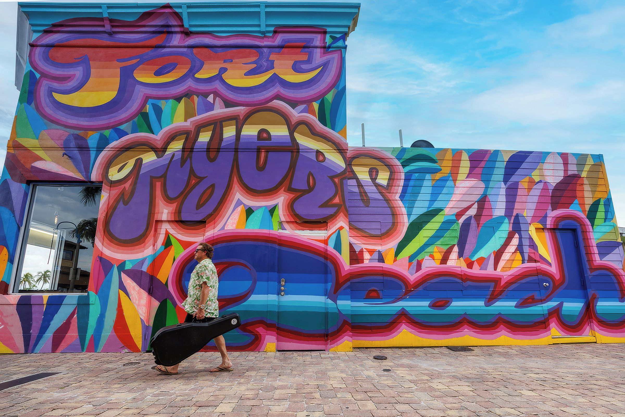 Un mural colorido con texto grande y formas abstractas en la fachada de un edificio.