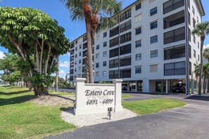 Een hotel met meerdere verdiepingen, met een bord dat 'Estero Cove 6891-6899' vermeldt.
