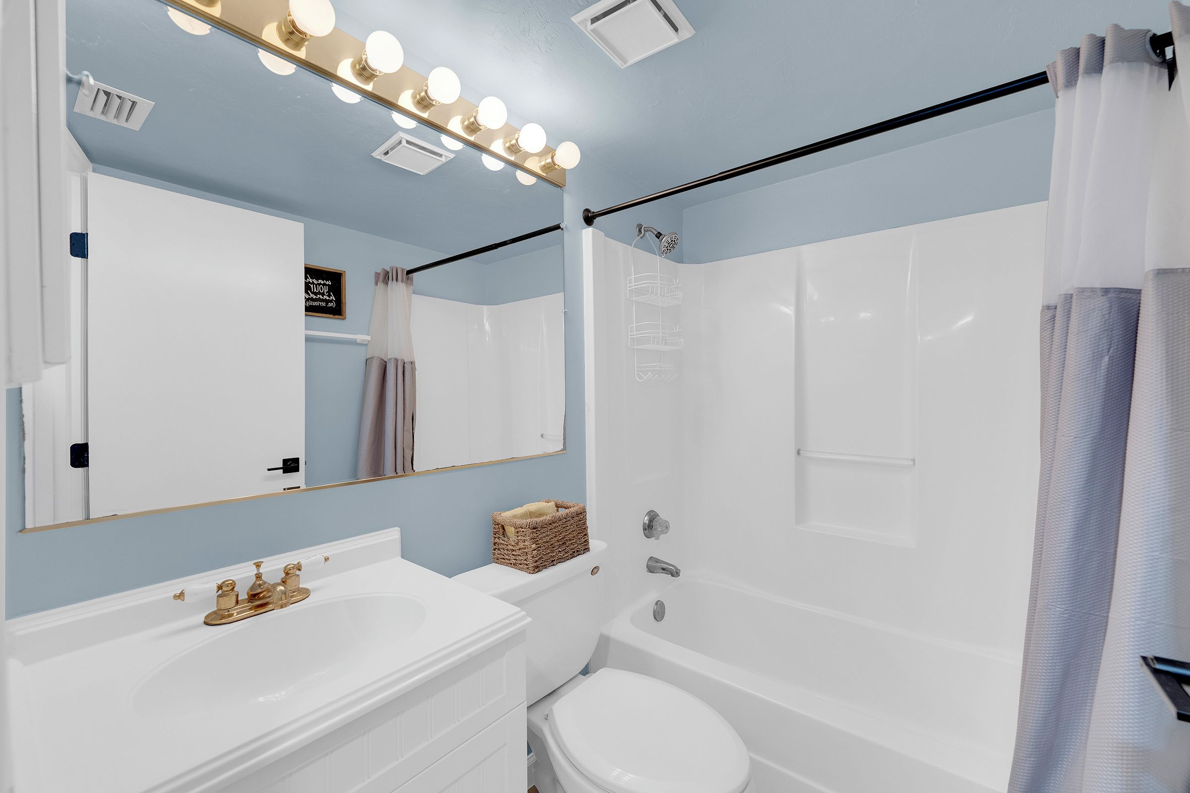 A bathroom with a vanity, a mirror, a shower, and a bathtub.