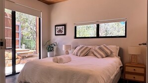 A bedroom with a large bed, a ceiling fan, and a view of the outdoors through a sliding door. - Private coastal villa with traditional sauna located in a beautiful bush setting (Margaret River)