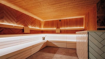 Eine Sauna mit Holzbänken und einer Wand im Fischgrätmuster.