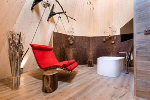 Ein modernes Interieur mit einem Hängestuhl, einer Badewanne und einer Ziegelwand.