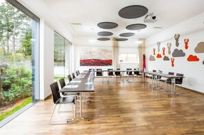 Ein Konferenzraum mit einem langen Tisch, Stühlen und einem Projektor.