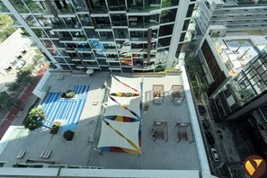 Um edifício alto com várias varandas e um pátio com áreas de estar.