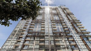 Un edificio alto con varios balcones y ventanas grandes.