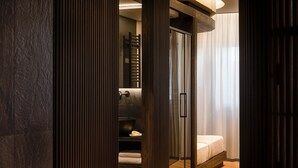 A modern bathroom with a glass shower enclosure, a wooden vanity, and a towel rack. - Bullet Athens (Athina)