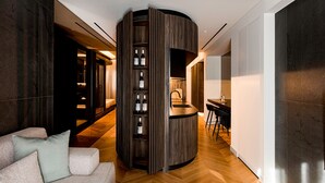 A modern interior with a curved wooden structure, a sofa, and a dining area. - Bullet Athens (Athina)