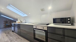 Eine moderne Küche mit Oberlicht, Backofen und Mikrowelle.