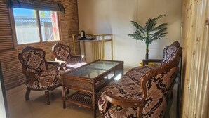 A room with a glass-top coffee table, patterned chairs, a sofa, a small table with a plant, and a window with blinds. - The Chail Heights Hotel & Resort (Shimla)