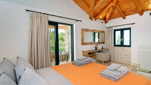 A bedroom with a bed, a desk, a mirror, and a view of the outdoors. - Serenity Near the Sea (Gaios)