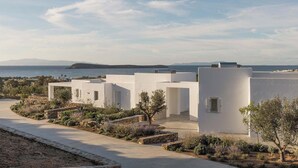 A coastal building complex with white walls and a clear view of the sea and distant mountains. - Golden Coast Villa Citron Private Wadingpool Gem (Paros)