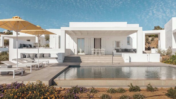 A modern outdoor pool area with white lounge chairs, a yellow umbrella, and a clear blue sky. - Golden Coast Villa Citron Private Wadingpool Gem (Paros)