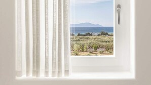 A window with white curtains, a view of a landscape with fields and distant mountains. - Golden Coast Villa Citron Private Wadingpool Gem (Paros)