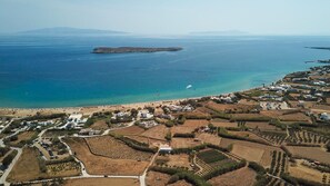 Luchtbeeld van een kustgebied met een strand, woongebouwen en akkerland.