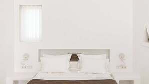 A minimalist bedroom with a bed, white walls, and a window with sheer curtains. - Golden Coast Villa Rodi Private Wadingpool Gem in Paros (Paros)