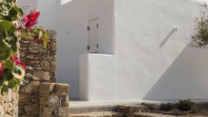 A modern building with a white facade, stone steps, and a small door. - Golden Coast Villa Rodi Private Wadingpool Gem in Paros (Paros)