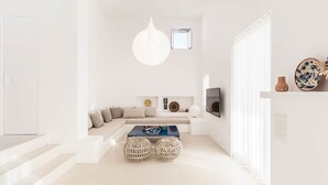 A modern living room with a sofa, coffee table, and decorative items. - Golden Coast Villa Daphne Private Wadingpool Getaway (Paros)