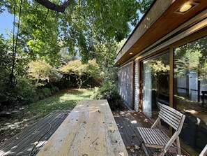 A wooden deck with a bench, surrounded by lush greenery and a tree. - House Pedro de Valdivia Norte - Garden & Parking (Las Condes)