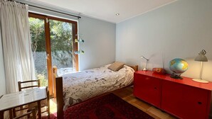 A bedroom with a bed, a desk, a red cabinet, and a globe. - House Pedro de Valdivia Norte - Garden & Parking (Las Condes)