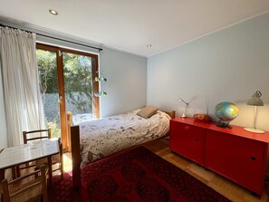 A bedroom with a bed, a desk, a red cabinet, and a globe. - House Pedro de Valdivia Norte - Garden & Parking (Las Condes)