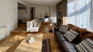 A modern living room with a fireplace, a sofa, a coffee table, and a view of the outside. - House Pedro de Valdivia Norte - Garden & Parking (Las Condes)