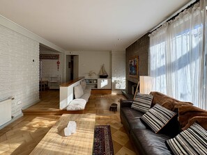 A modern living room with a fireplace, a sofa, a coffee table, and a view of the outside. - House Pedro de Valdivia Norte - Garden & Parking (Las Condes)