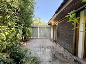 A paved patio with a sliding glass door leading to a covered outdoor area. - House Pedro de Valdivia Norte - Garden & Parking (Las Condes)