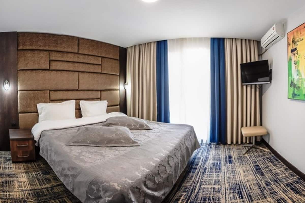 Suite, balcón, vista al jardín | Caja de seguridad en la habitación, cortinas blackout y wifi gratis