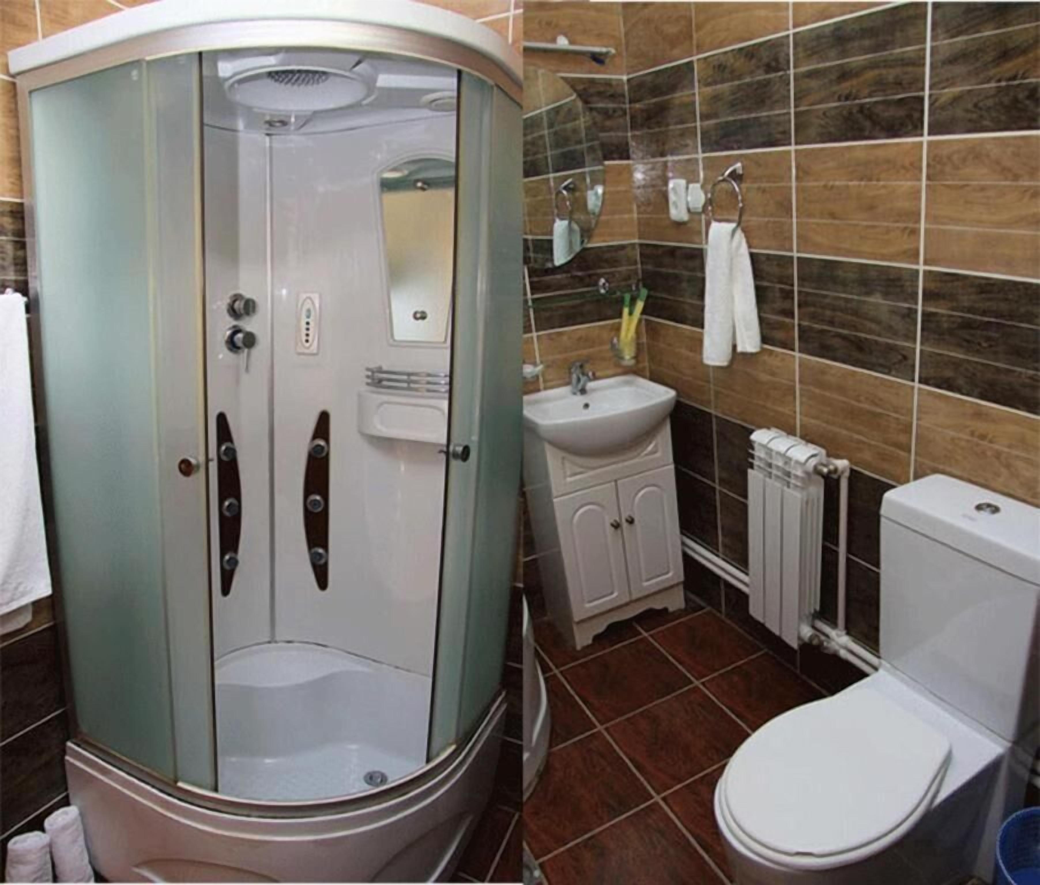 Bagno con doccia a filo pavimento, lavandino, wc e porta asciugamani.