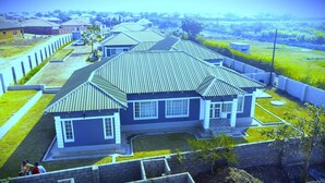 A residential house with a sloped roof, a front porch, and a well-maintained lawn.