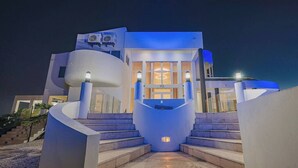 A modern building with a unique architectural design, featuring a central staircase leading to a large entrance.