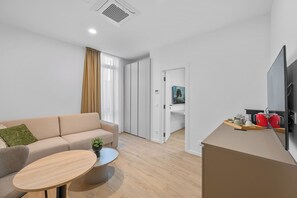 Un salon moderne avec un canapé, une table basse et un téléviseur à écran plat.
