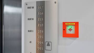 An elevator control panel with floor numbers and a garage indicator.