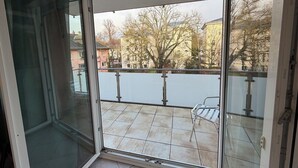 A balcony with a view of buildings and trees.