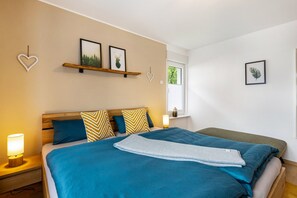Une chambre à coucher comprenant un lit, des tables de chevet, une fenêtre et des éléments de décoration murale.